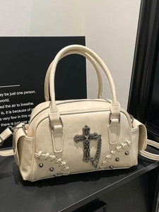 Sac à main gothique crème avec croix métalliques et chaîne sur fond de studio noir
