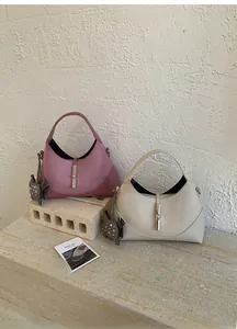 Detail of hobo handbag in pink and cream leather featuring a distinct silver metal clasp