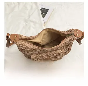 Détail intérieur d'un sac besace en paille avec doublure en tissu beige et poche plate