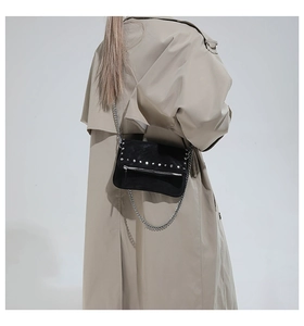Détail du sac à chaîne noir clouté avec rivets argentés et fermetures à glissière