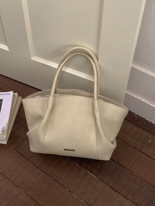 Sac fourre-tout minimaliste en cuir texturé crème avec plaque logo métallique
