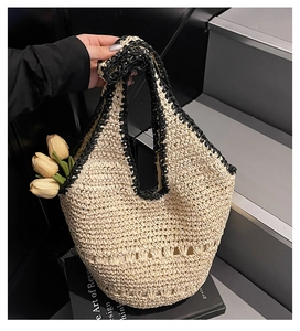 Detailed macro view of cream straw woven tote bag featuring black crochet trim and patterns