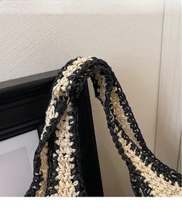 Close-up of the woven shoulder strap featuring a black and beige checkered pattern