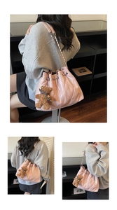 Detail of pink quilted drawstring bucket bag with silver chain and cute teddy bear charm