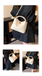 Detail of cream lychee leather bucket bag with gold hardware and fine grain texture