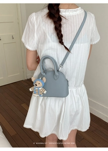 Minimalist blue shell bag detail with lychee texture and cute bear charm accessory