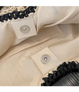 Detail of straw tote bag with beige cotton lining and silver magnetic snap closure