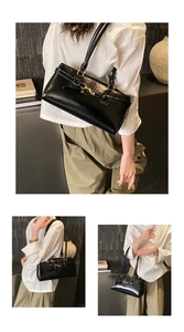 Detail of black glossy rectangular handbag with golden horsebit hardware and leather straps