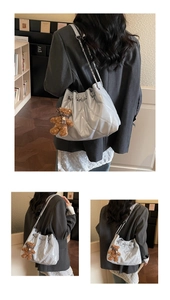 Detail of light gray quilted bucket bag with silver chain and plush bear charm decoration