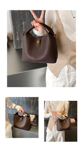 Detail of dark brown lychee grain leather bucket bag with gold metal twist lock