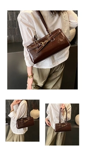 Detailed view of dark brown vintage patent leather baguette bag with gold buckle