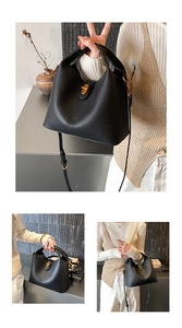 Detail of black pebbled leather bucket bag with gold twist lock and adjustable strap