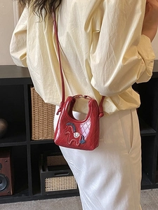 Mini red quilted leather crossbody bag with horse charm on elegant model display