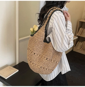 Detailed hollow weave texture and contrast black trim on a beige straw hobo tote bag
