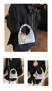 Detailed view of light blue ruched cloud bag featuring silver chain and plush bear charm