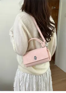 Pink crossbody square bag with silver turn-lock clasp and knotted handle detail