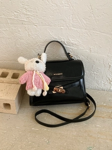 Chic black bucket handbag with gold hardware and a cute puppy charm accessory