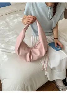 Detail of light pink pleated hobo bag with zipper closure and natural soft faux leather texture