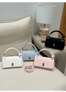 Group of textured faux leather handbags in four colors featuring unique knotted top handles