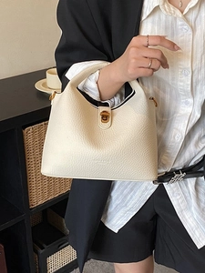 Chic beige lychee grain leather bucket bag with gold lock for elegant daily commute