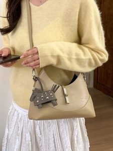 Contrast color bucket bag with horse charm and silver buckle shown in a lifestyle setting