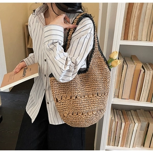 Detail of hand-woven hollow straw tote bag with black trim and spacious interior