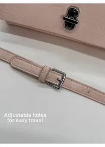 Detail of pink leather handbag showing silver twist lock and adjustable shoulder strap
