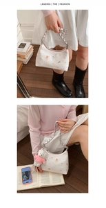 Detail der weißen Stepptasche mit rosa Bärenstickerei und silberner Kettenriemen