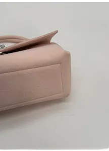 Detailed close-up of a pink handbag featuring a reinforced wide base for structure