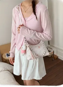 Detail der Vintage-Handtasche mit Cartoon-Print, Silberkette und kleinem Bär-Anhänger