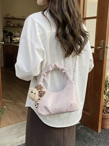 Pink pleated dumpling bag with teddy bear charm and silver chain for women stylish use