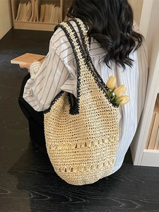 Straw tote bag with black crochet trim and cutout details for summer beach vacations