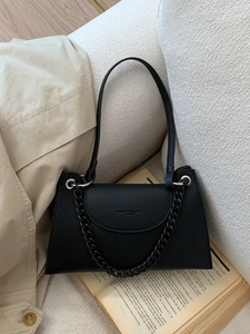 Vintage black lychee pattern leather handbag with chain strap on a minimalist lifestyle setting