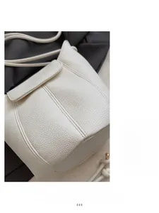 Detail of white lychee pattern leather bucket bag showing soft texture and fine stitching