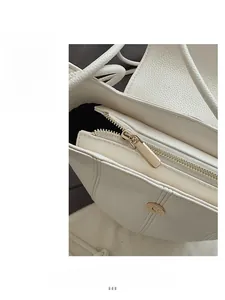 Close-up of premium white leather texture with smooth golden zipper and refined stitching