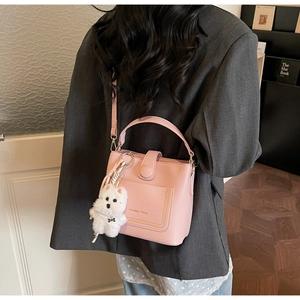 Sac seau rose à texture litchi avec breloque chien en peluche et bandoulière réglable