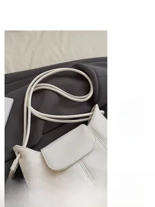 Detail of lychee textured leather and soft round strap on a cream bucket bag