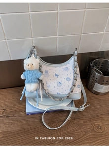 Detail der blau-weißen Halbmondtasche mit Bärenprint, Kette und Plüsch-Anhänger