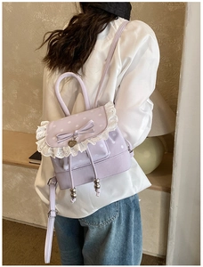 Vue détaillée du sac à dos violet à pois avec dentelle blanche et pendentif coeur