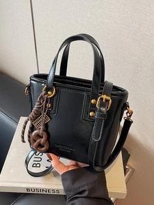 Retro black leather bucket bag with vintage gold hardware and abacus charm detail