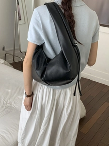 Minimalist black leather hobo shoulder bag with drawstring detail and silver zipper