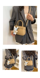 Detailed views of khaki pebbled leather handbag with adjustable buckle and bunny charm