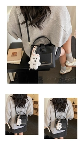 Détail d'un sac seau noir en cuir grainé avec un charmant pendentif chien en peluche