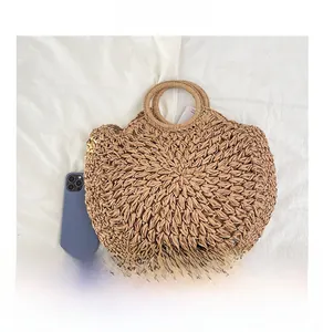 Détail de la paille tressée avec poignée ronde et téléphone bleu pour référence de taille