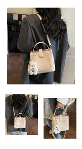 Gros plan du sac seau crème avec texture grainée et charmant pendentif chiot en peluche