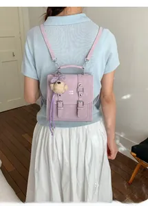 Close-up of lavender mini backpack with plush bear charm and ribbon on model back
