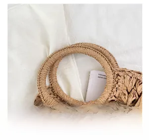 Détail des poignées rondes tressées sur un sac de plage en paille naturelle
