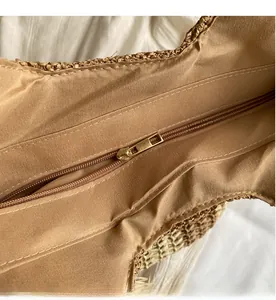 Detail view of smooth zipper closure and fabric lining on woven straw beach tote bag