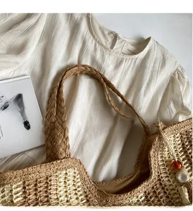 Gros plan du sac cabas en paille tissé à la main avec de larges anses confortables