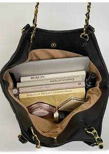 Interior view of large black quilted tote bag showing laptop and daily essentials